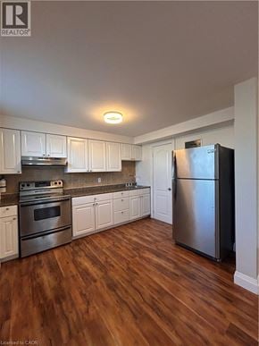 Hamilton apartment for rent - A kitchen with white cabinets and a stainless steel refrigerator.
