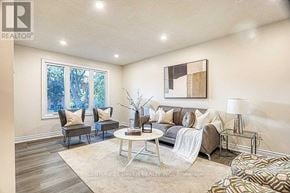 Hamilton (Gilkson) apartment for rent - A living room with a grey couch, a white coffee table, and a painting on the wall.