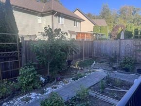 Surrey apartment for rent - A backyard with a wooden fence and a vegetable garden.