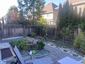 Surrey apartment for rent - A backyard with a fence, a hose, and a table.