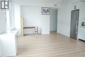 Burnaby apartment for rent - A white kitchen with a fridge and a table.