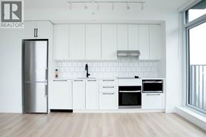 Burnaby apartment for rent - A modern kitchen with white cabinets and a stainless steel refrigerator.
