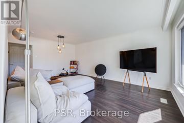 Toronto (Bendale) apartment for rent - A living room with a white couch and a black TV on a stand.