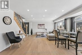 Brampton (Northwest Brampton) townhouse for rent - A living room with a staircase, a couch, a chair, and a table.