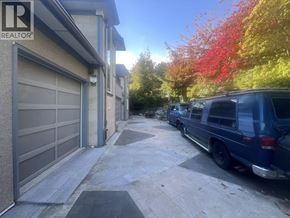 West Vancouver apartment for rent - A blue van is parked on a driveway in front of a house with a sign that says REALTOR.
