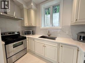 West Vancouver apartment for rent - A kitchen with white cabinets and a stove top oven.