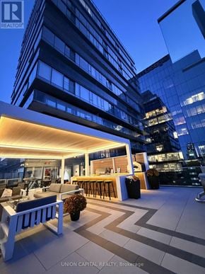 Toronto (Church-Yonge Corridor) condo for rent - A modern outdoor seating area with a bar and comfortable seating.