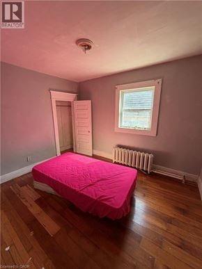 Brantford apartment for rent - A bedroom with a pink bedspread and a window with a view of the ocean.