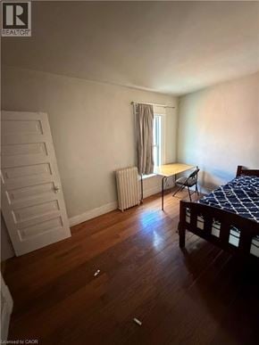 Brantford apartment for rent - A bedroom with a bed, chair, and window.