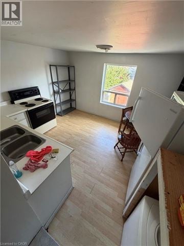 Brantford apartment for rent - A kitchen with a sink, stove, and a window.