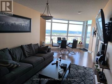 Toronto (Agincourt South-Malvern West) condo for rent - A living room with a large couch and a view of the beach.