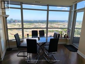 Toronto (Agincourt South-Malvern West) condo for rent - A dining room with a table and chairs in front of a large window overlooking a cityscape.