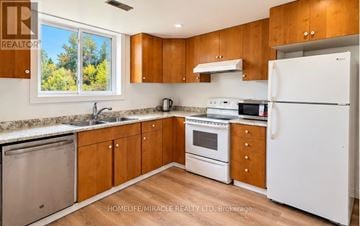 Guelph (Kortright Hills) apartment for rent - A kitchen with wooden cabinets and a white refrigerator.