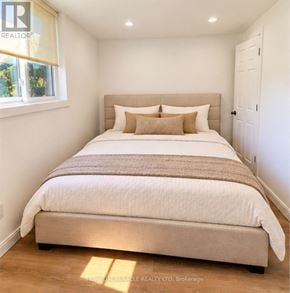 Guelph (Kortright Hills) apartment for rent - A bedroom with a large bed and a window letting in natural light.