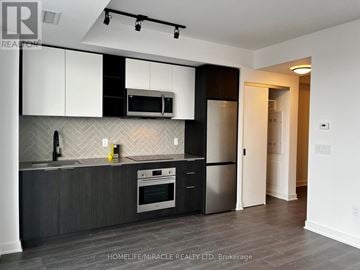 Toronto (Islington-City Centre West) condo for rent - A modern kitchen with dark wood floors and white cabinets.