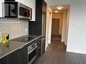 Toronto (Islington-City Centre West) condo for rent - A kitchen with a black counter top and a microwave above it.