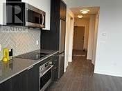 Toronto (Islington-City Centre West) condo for rent - A kitchen with a black counter top and a microwave above it.