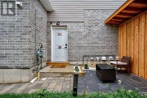 Stratford apartment for rent - A small patio with a white door and a brown bench.