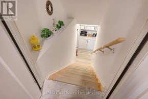 Stratford apartment for rent - A staircase with a wooden handrail and a wreath on the wall.