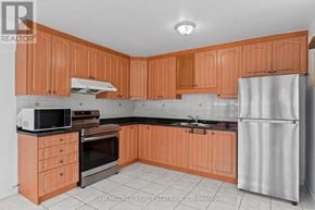 Toronto (Humber Summit) apartment for rent - A kitchen with wooden cabinets and a refrigerator.