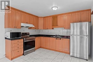 Toronto (Humber Summit) apartment for rent - A kitchen with wooden cabinets and a refrigerator.