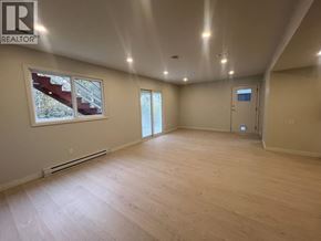 Maple Ridge apartment for rent - A spacious room with wooden flooring and a large window.