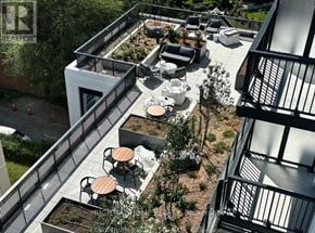 Toronto (Forest Hill South) condo for rent - A balcony with a table and chairs overlooks a garden.