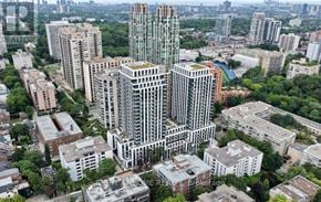 Toronto (Forest Hill South) condo for rent - A cityscape with a mix of modern and older buildings, with a large green space in the foreground.