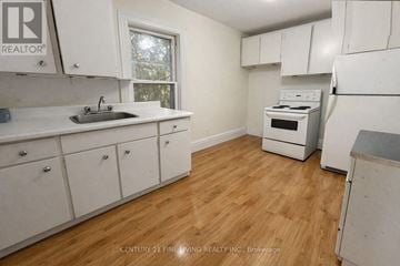 Barrie (City Centre) apartment for rent - A kitchen with white cabinets and a wooden floor.