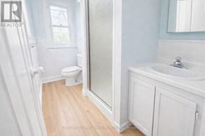 Barrie (City Centre) apartment for rent - A white bathroom with a toilet, sink, and mirror.