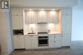 Toronto (Waterfront Communities) condo for rent - A kitchen with white cabinets and appliances in Brokerage by Master's Trust Realty Inc.