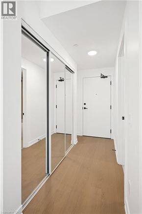 Toronto condo for rent - A hallway with white walls and wood flooring.