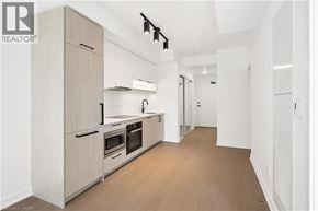 Toronto condo for rent - A modern kitchen with wooden floors and white walls.