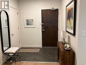 St John's house for rent - A hallway with a brown door, a mirror, a bench, and a painting on the wall.