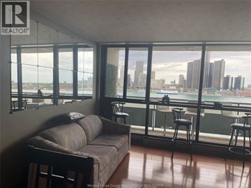 Windsor condo for rent - A living room with a couch and a view of the city.