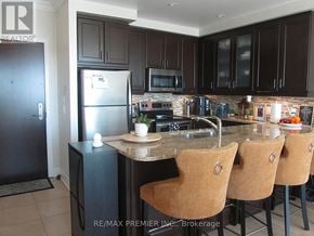Brampton (Downtown Brampton) condo for rent - A kitchen with a refrigerator, microwave, oven, and sink.