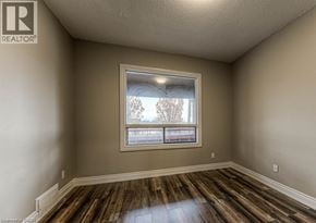 Hamilton apartment for rent - A room with a window and wooden floors.