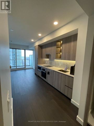 Toronto (Bayview Village) condo for rent - A modern kitchen with dark wood floors and white walls.