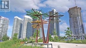 Toronto (Bayview Village) condo for rent - A large metal sculpture of a palm tree stands in front of a city skyline.
