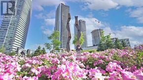 Toronto (Bayview Village) condo for rent - A field of pink flowers in the foreground with modern buildings in the background.