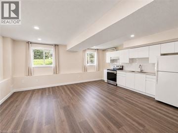 Waterloo apartment for rent - A well-lit, spacious kitchen with white cabinets and a wooden floor.