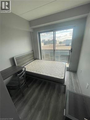 Waterloo condo for rent - A bedroom with a bed, desk, and chair.