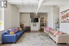 Kitchener condo for rent - A living room with a blue couch and a rug.