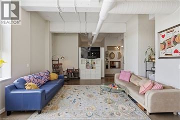 Kitchener condo for rent - A living room with a blue couch and a rug.