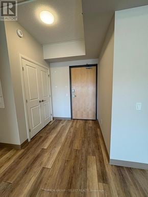London South (South J) condo for rent - A hallway with wood flooring and a white door.
