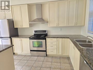 Vaughan (East Woodbridge) townhouse for rent - A kitchen with white cabinets and a black stove top oven.