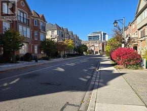 Vaughan (East Woodbridge) townhouse for rent - A street view of a residential area with houses on both sides and a clear blue sky.