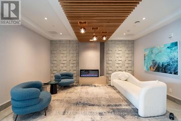 Barrie (Little Lake) condo for rent - A modern living room with a fireplace and a large painting on the wall.