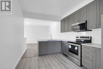 Ottawa townhouse for rent - A kitchen with grey cabinets and stainless steel appliances.