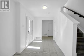 Ottawa townhouse for rent - A white hallway with a staircase on the right and a door on the left.
